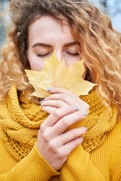 Rothaarige lockige schöne Mädchen mit geschlossenen Augen hält gelbe Karte — Stockfoto