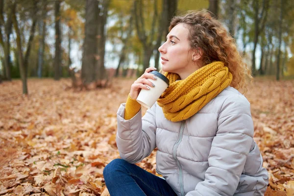 Mädchen sitzt auf den Herbstblättern, entspannt und genießt die Aussicht — Stockfoto