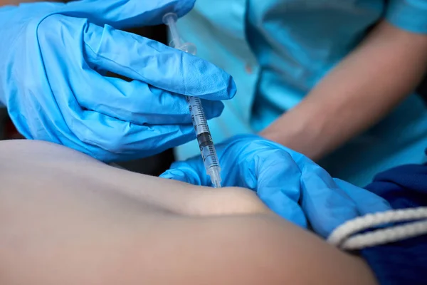 Manos de enfermera en guantes quirúrgicos azules haciendo inyección de antic —  Fotos de Stock