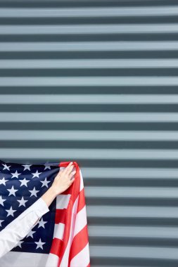Kadın elleri, gri bir duvara ABD bayrağı asmak, abd bağımsızlık