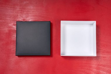 Kırmızı ahşap masada duran açık ve boş hediye kutusu. Üst görünüm.