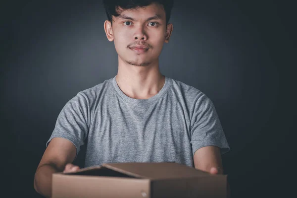 Portrait of a man delivering parcels on a black background