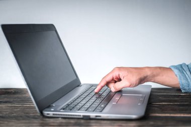 Masadaki bilgisayara işaret eden bir jest gösteren kot gömlek giyen bir adamın eli beyaz bir arka plan, iş konsepti, teknoloji konsepti....