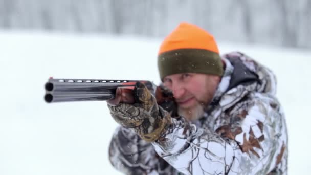 The hunter with double-barreled rifle. The hunter in camouflage targets with a rifle — Stock Video