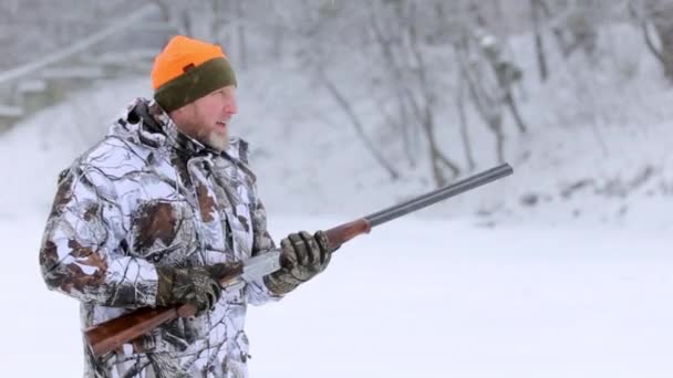 The hunter with double-barreled rifle. The hunter in camouflage targets with a rifle. Slowmotion — Stock Video