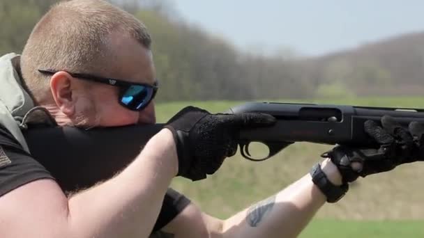 Vista panorámica del hombre en objetivos de camuflaje con una escopeta — Vídeos de Stock