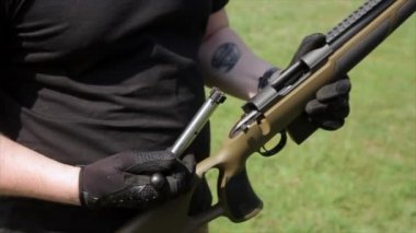 Karabina yakından görmek. Eller adamın bir karabina şarj prensibi gösterir