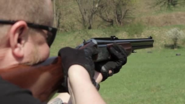 Un hombre con rifle de doble cañón. El hombre de gafas apunta con un rifle — Vídeo de stock