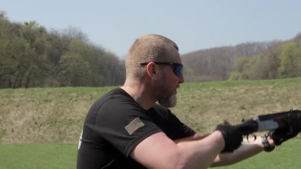 Muž s dvouhlavňová puška. Muž v cíli brýle s puškou — Stock video