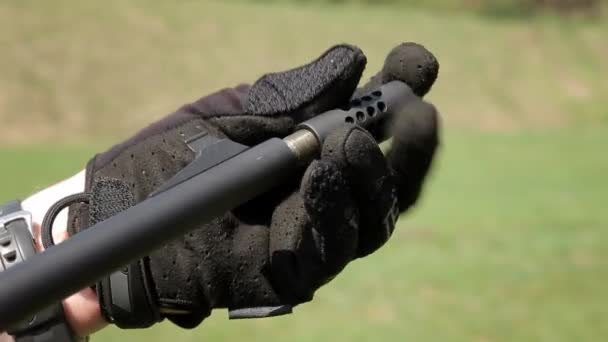 Un primer plano del cañón de la carabina. La mano de Mans fija el silenciador a la carabina — Vídeos de Stock