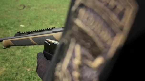 A close-up view of carbine. Mans hands demonstrates the charge a carbine with bullets — Stock Video