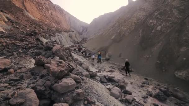 En grupp turister promenader throught färgade öde steniga backen. Hormuz ön. Iran — Stockvideo