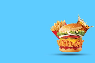 Hamburger, patates kızartması, cola içecek. Paket servisi olan restoran yiyecek. Mavi arka plan üzerinde fast food. Kopya alanı