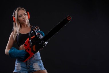 İnşaat işçisi çalışan chainsawattractive kadın ile poz çekici genç bir kadın. Bir kadın inşaat işçisi portresi. Bina, kavram onarın. Feminizm ve cinsiyet eşitliği. Boşaltmak