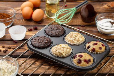 Farklı kek tasarlayacağım veya çörek tepsisi broun ahşap arka plan üzerinde. Temel muffin tarifi. Ev yapımı kekler kahvaltı ya da tatlı için. Malzemeler