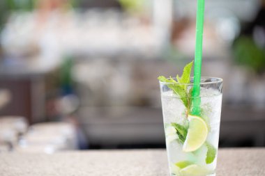 Yakın çekim mojito kokteyl limon ve nane çubuğunda, Restoran arka plan. Kopya alanı