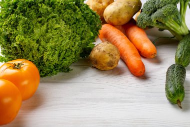 Beyaz ahşap zemin üzerinde çeşitli ham organik sebze ile kompozisyon