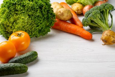 Beyaz ahşap zemin üzerinde çeşitli ham organik sebze ile kompozisyon