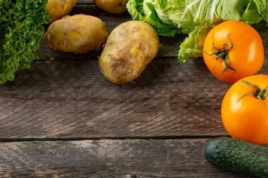 Broun ahşap arka plan üzerinde çeşitli ham organik sebze ile kompozisyon