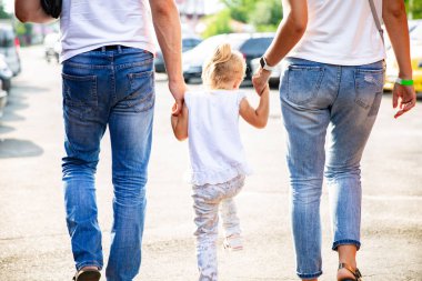 Aile açık havada tutan yürüyüş eller. Arkadan görünüm. Rahat anne ve kızları orta