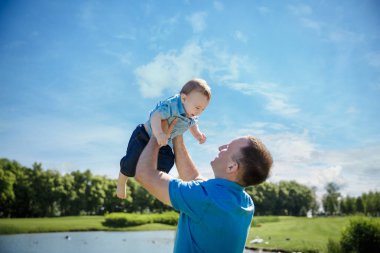 Babası oğlunun havaya kusuyor. Aile zaman birlikte. Mutlu küçük çocuk babası ile eğleniyor