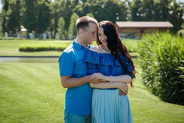 Park ağaç üzerinde oturan kıyafetler yürüyen genç bir çift