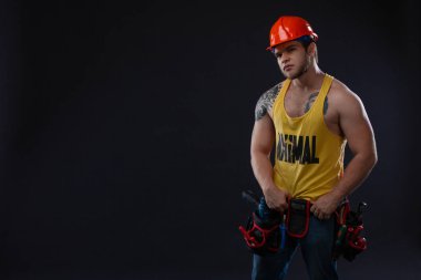 Ağır sanayi ve iş kavramı - emin yüz ifadesi olan adam. Kas seksi profesyonel Oluşturucusu, koruyucu kask tamirci. Acımasız adam dövme siyah bir zemin üzerine