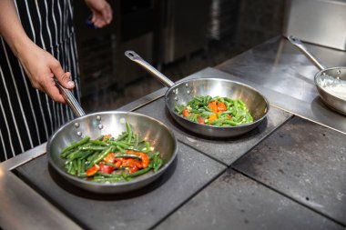 Izgara sebze hazırlanması işlemidir. Sebze ızgara tava üzerinde. Şef'in eller. kuşkonmaz ve profesyonel mutfak Bulgar biber