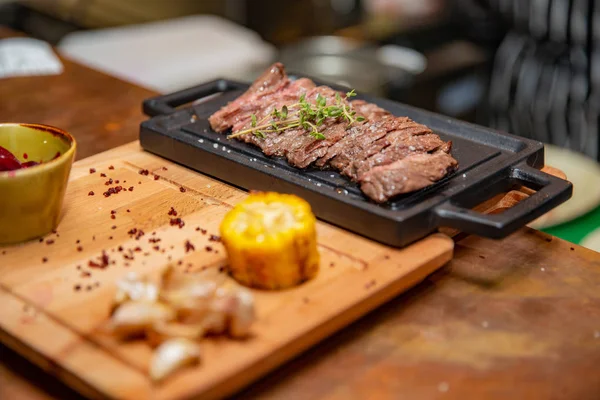 Masada ızgara kaburga bifteği ve sarı patates dilimleri ve tabağın üstündeki tabakta yağ ile fotokopi alanı.