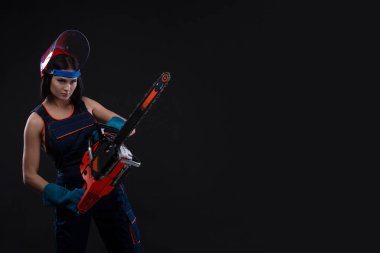 güzel sıcak seksi kadın bir chainsaw siyah arka plan üzerinde tutun. Kopya alanı