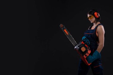 güzel sıcak seksi kadın bir chainsaw siyah arka plan üzerinde tutun. Kopya alanı