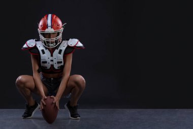 Ragbi topu ile çalışan ve agresif çığlık siyah arka plan cinsel sportif kadın. Uzay kopyalayın. cinsiyet eşitliği