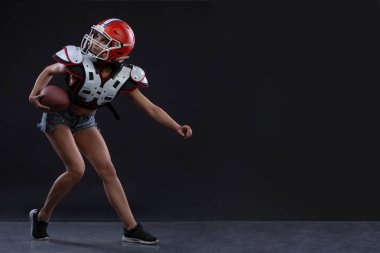 Ragbi topu ile çalışan ve agresif çığlık siyah arka plan cinsel sportif kadın. Uzay kopyalayın. cinsiyet eşitliği