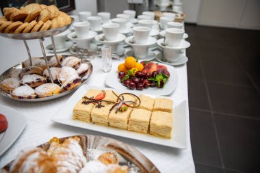 Napolyon kek çilek ve çikolata cips ile dekore edilmiştir. ay çöreği, kek ve meyve büfesi masada. Tatlı tablo