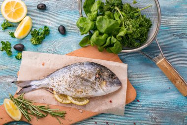 Taze balık dorado üstten görünüm. Ahşap tahta pişirme ıspanak ve limon sağlıklı gıda baharat