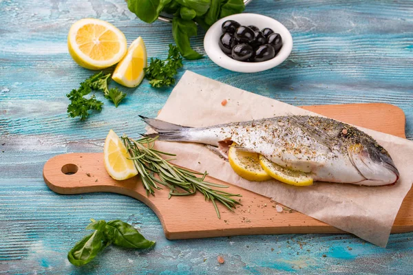 Taze balık dorado üstten görünüm. Ahşap tahta pişirme ıspanak ve limon sağlıklı gıda baharat