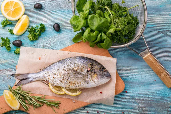 Taze balık dorado üstten görünüm. Ahşap tahta pişirme ıspanak ve limon sağlıklı gıda baharat