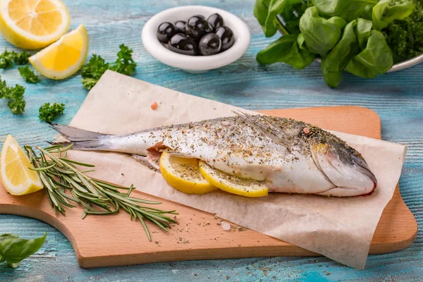 Taze dorado balık. Kara taş tahta pişirme baharatlı sebze ve ot sağlıklı gıda baharat. pişirme işlemi
