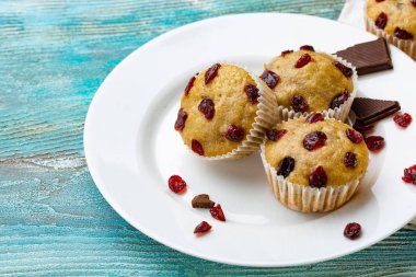 Ev yapımı kek kiraz ile hafif bir arka plan üzerinde yer alır. Bir kaç top kek beyaz bir tabak ön planda yer alan.