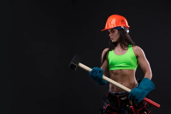 sexy female miner worker with pickaxe, in coveralls over his naked body