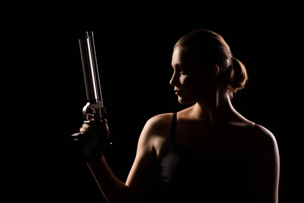 Military woman with a sport gun over black background