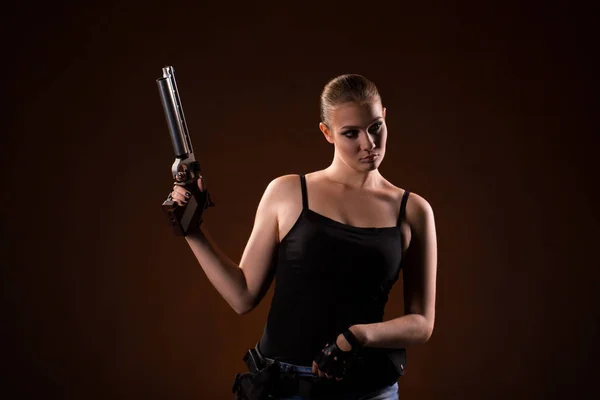 Femme militaire avec un pistolet sur fond noir — Photo