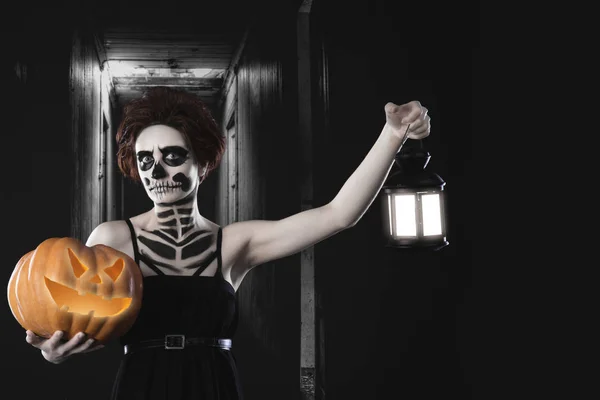 Retrato de mulher com maquiagem esqueleto halloween segurando abóbora e lâmpada — Fotografia de Stock