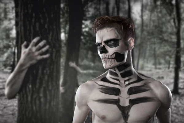 Dia de los Muerto kostüm - ölülerin günü Meksika tatildir. Kafatası yüz korkunç orman ve zombiler arka planı olan bir adam burada. Cadılar Bayramı