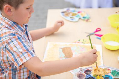 Sevimli küçük çocuk Sonbahar Park renkli boya ile çizim. Yaratıcı çocuk doğa üzerinde boyama. Açık havada etkinlik yürümeye başlayan çocuk için. Yetenekli yürümeye başlayan çocuk ressam