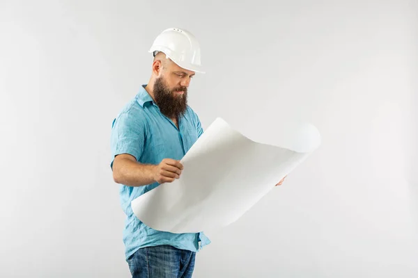 Rollo de papel hombre chaleco reflectante casco. arquitecto considera dibujos sobre fondo whute — Foto de Stock