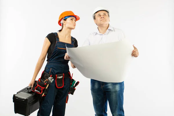 Portrait Of Male Architect And builder Woman Discussing building plan. foreman holding roll paper