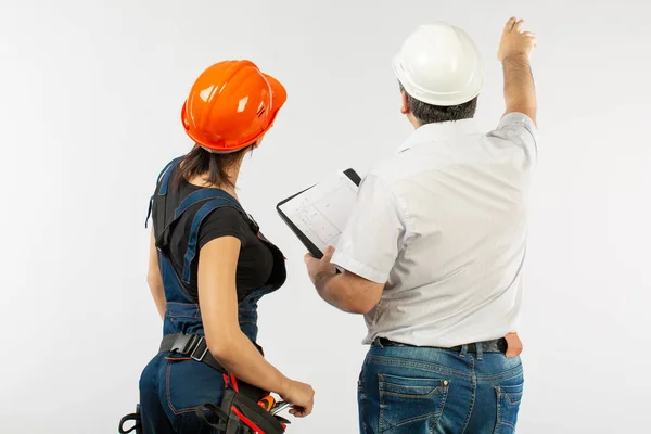 Constructores en hardhat o casco discutir planos con la tableta — Foto de Stock