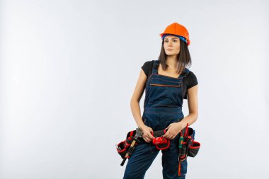 Kask ve kemer beyaz arka plan üzerinde araçları ile güzel Oluşturucusu kız