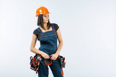 Kask ve kemer beyaz arka plan üzerinde araçları ile güzel Oluşturucusu kız